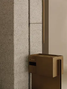 Cozy room with a large stone wall, wooden accents, and a brown box on the floor, lit by dim lighting