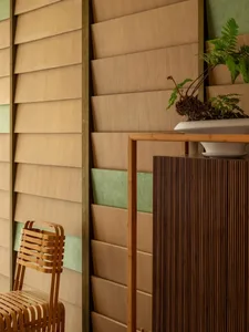 Warm and inviting living space with wooden walls, a wooden chair, and a potted plant on a shelf