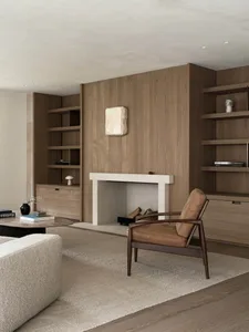 Cozy living room with a fireplace, wood furniture, and natural light from windows