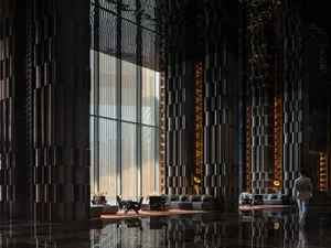 Modern commercial space with black and white color scheme, metal-framed window, and dim lighting, featuring furniture and a cozy atmosphere