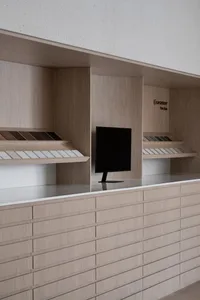 Dimly lit living room with a wooden cabinet, a countertop, and a mounted TV