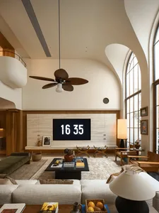 A well-lit living room with modern furniture, a TV, and decorative items, set against a neutral background with natural light from windows