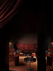 Cozy living room with brown furniture, a red curtain, and dim lighting