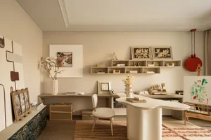 Bright and inviting living room with a white desk, chair, rug, and vases, featuring modern and stylish furniture and decorations