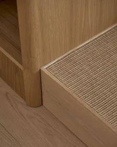 A residential space with a wooden floor and carpeted step, lit by natural sunlight from a window, creating a warm and cozy atmosphere