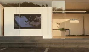 現代生活室，擁有大螢幕電視、玻璃門和植物，呈現簡約設計和自然光線