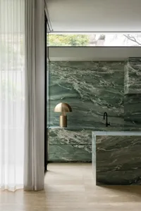 Bathroom with a marble countertop and sink, large window, and modern design