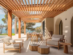 A modern outdoor living area with a wooden deck and patio, featuring a dining table, chairs, couch, and bench, surrounded by a potted plant, creating a comfortable and inviting atmosphere with a natural and warm ambiance