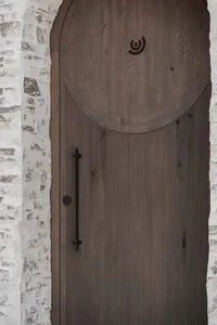 A wooden doorway with a brown door open to reveal a warm and inviting interior
