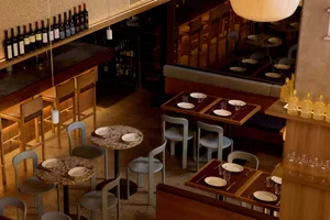 Cozy restaurant interior with wooden furniture, white plates, and dim lighting