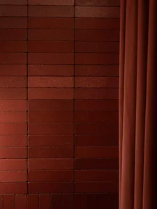 A red brick wall in a possible theater setting, illuminated by natural light