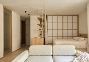 Cozy bedroom with a bed, couch, and bookshelf, featuring wood and fabric materials in a well-lit space