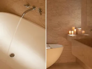 Modern bathroom with a white jacuzzi tub, sink, and shower, featuring clean lines and minimalistic design, with natural light and a relaxing atmosphere