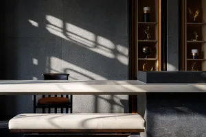 Dining room with a large marble table, black chairs, a couch, and a vase, set in a dimly lit space