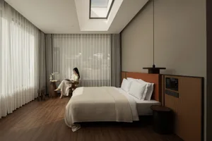 A well-lit bedroom with a bed, a wooden chair, and a window, featuring a modern and comfortable style