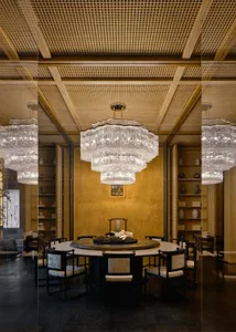 Formal dining room with a gold and white color scheme, a large dining table, and elegant vases
