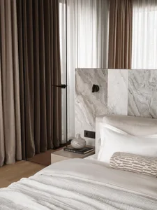 Bedroom with a bed, nightstand, and marble wall, featuring a modern and elegant style