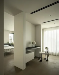 A modern bedroom with a white color scheme, featuring a bed, chair, desk, and mirror, with a focus on simplicity and clean lines, and soft diffused lighting