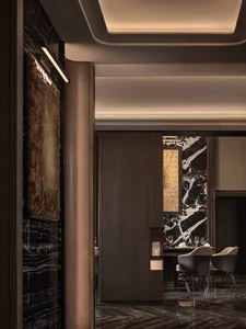 A modern restaurant interior with wood and marble surfaces, soft warm lighting, and comfortable seating for guests