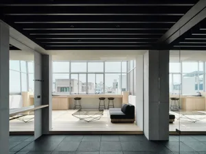 Cozy living room with a black and white color scheme, a large window, a couch, and a dining table