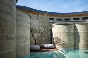 A modern outdoor space with a pool, patio, and various materials, including concrete, wood, and stone, in a well-lit and inviting atmosphere
