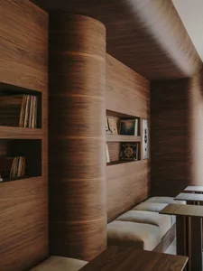 Cozy living space with wooden walls, a wooden bench, and books scattered around the room, creating a warm and inviting atmosphere