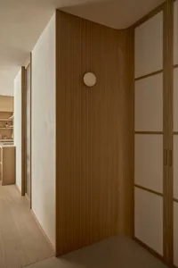 Cozy kitchen with wooden walls and floors, dim lighting, and a sink visible