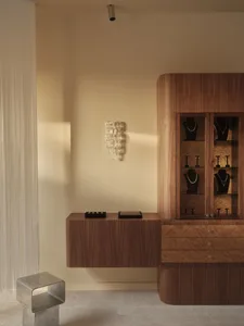 A modern store with a wooden desk and drawers, displaying necklaces on the wall and bracelets on the desk, with a clean and elegant atmosphere