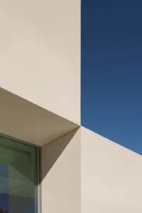 現代建築白色外牆，大的白色三角特徵，陽光照射在建築上