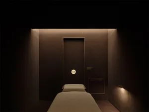 Cozy hotel bedroom with a bed, door, and window, featuring a modern style with wood materials and neutral colors