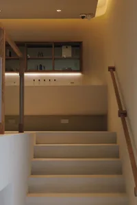 A cozy staircase with wooden steps, bottles on the steps, and a lived-in atmosphere