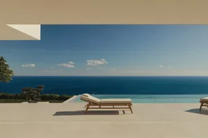 A serene outdoor patio with a white chair and couch on a white tile floor, overlooking a blue ocean with natural lighting and a clean modern aesthetic