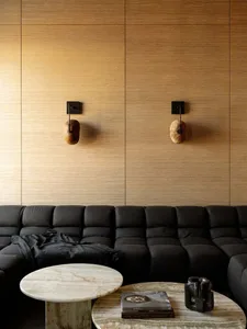 A modern living room with a wooden wall, a wooden table, and a comfortable atmosphere created by well-placed lighting