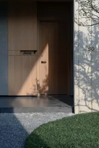 A doorway with a wooden door and glass window, set against a stone wall in a residential building