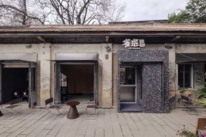 A dimly lit restaurant interior with a stone exterior, featuring a stone floor and stone-tiled roof, and a dining table surrounded by chairs