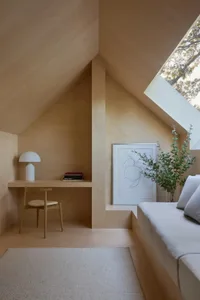 Cozy bedroom with a bed, desk, and chair, decorated with a potted plant and vase, featuring modern style and soft warm lighting