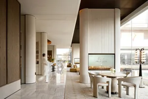Well-lit lobby with a large TV, comfortable seating, decorative elements, and a sophisticated atmosphere