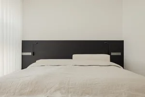 Cozy minimalist bedroom with a bed, nightstand, and dim lighting