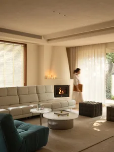 Cozy living room with a fireplace, white furniture, and natural light