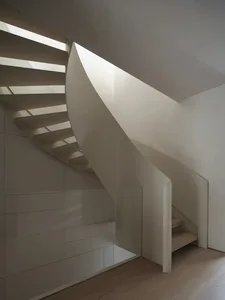 A simple wooden staircase in a house with natural light and a welcoming atmosphere