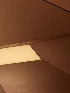 一間現代客廳，地板是木質，天花板燈光照亮，創造了一個溫暖和邀人的氣氛