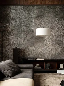 Cozy living room with a gray couch, a table lamp, and a bookshelf filled with books, set in a well-lit space