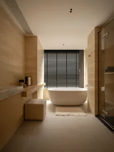 A bathroom with a white bathtub, sink, and toilet, set against a wooden floor and well-lit for a clean and inviting atmosphere
