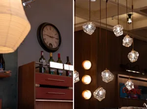 A modern kitchen with a wooden cabinet and a hanging light fixture, featuring a clock and neutral colors with natural tones