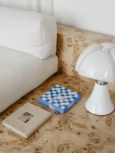 A well-lit living room with a white couch, a chair, and a lamp, suggesting a modern and minimalist style