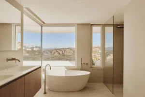 現代浴室內，白色 bathtubs、洗手盆和大型窗戶讓自然光照進入空間