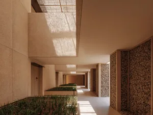 A well-maintained indoor hallway with a row of windows, lined with potted green plants, creating a pleasant atmosphere