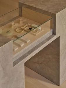 A display case filled with jewelry, cosmetics, and accessories, set against a neutral background, with a focus on the items' beauty and elegance