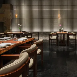 一間充滿光線的餐廳空間，擺設多張桌子和椅子，配備酒杯、花瓶和其他餐桌用具，營造出高雅的氛圍