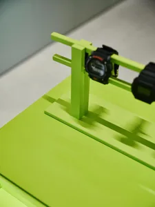 A green table with a digital clock on a green stand in a modern room with a green color scheme